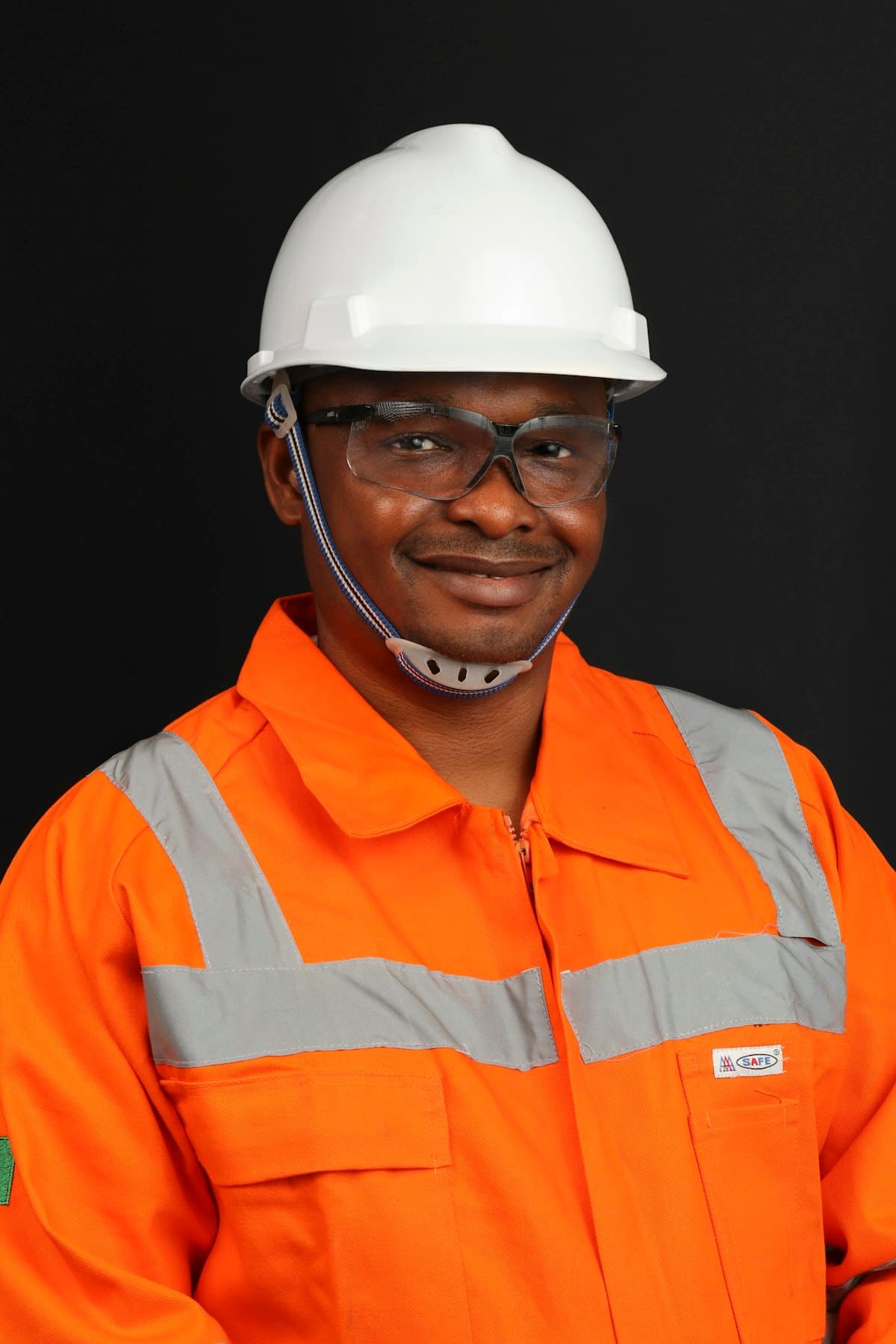 A smiling site worker in a hard hat and high-visibility jacket